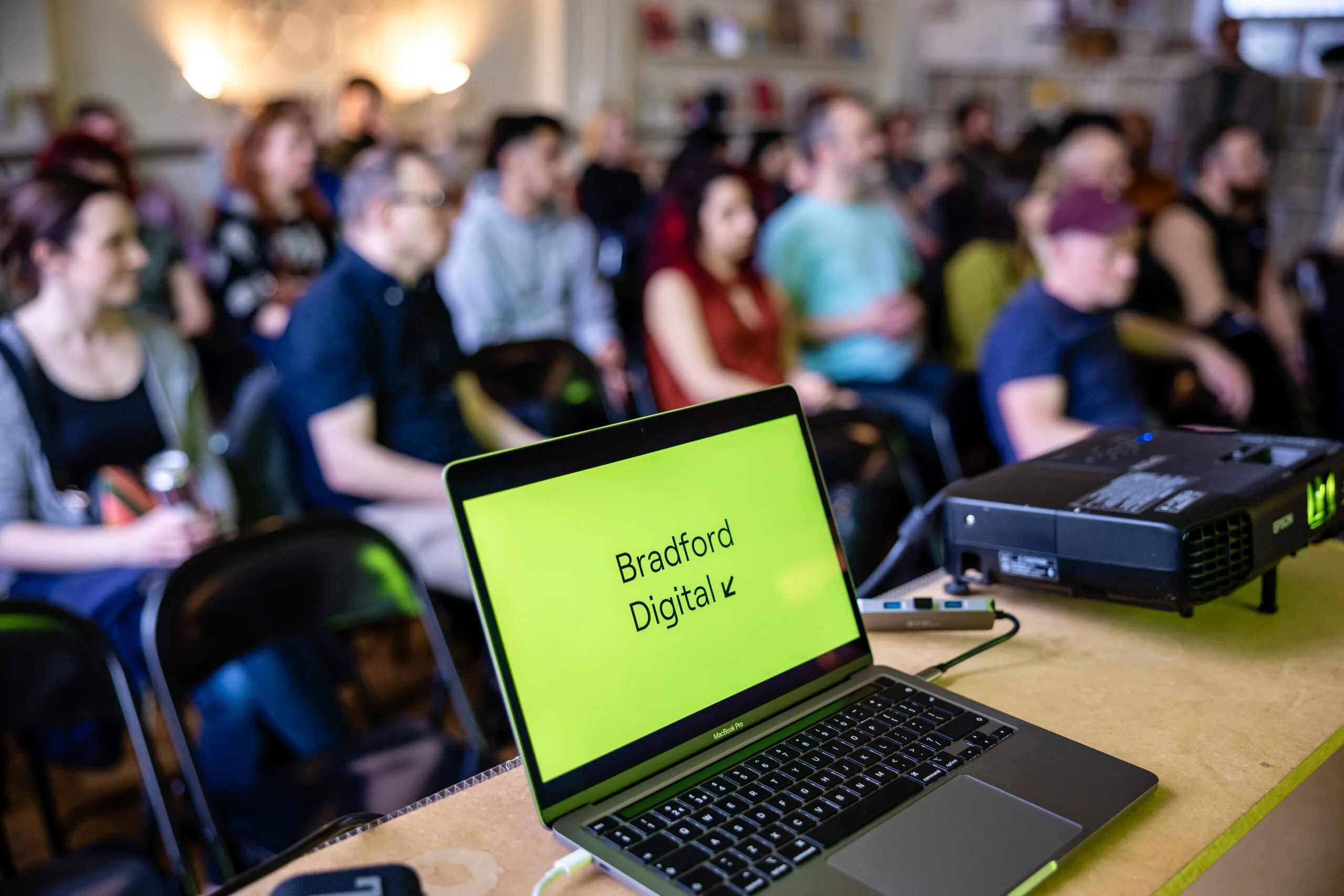 Bradford Digital logo on a laptop screen in front of a seated crowd